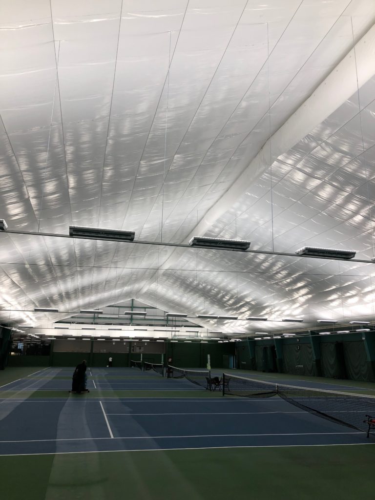 A tennis court with a white ceiling.